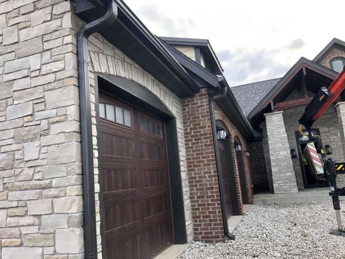 Black seamless gutters installed above a residential garage