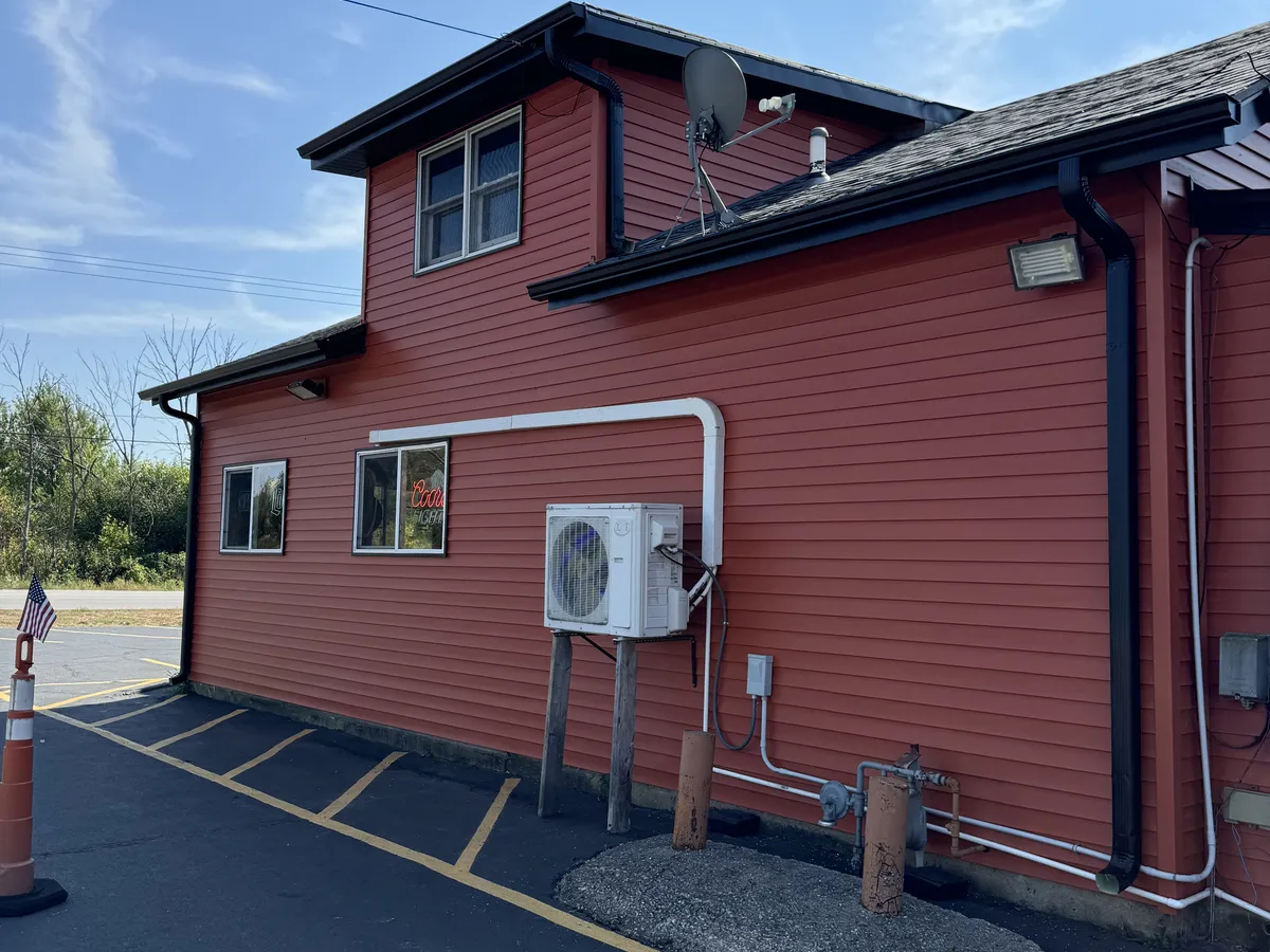 White gutters and downspout installed on a red commercial building