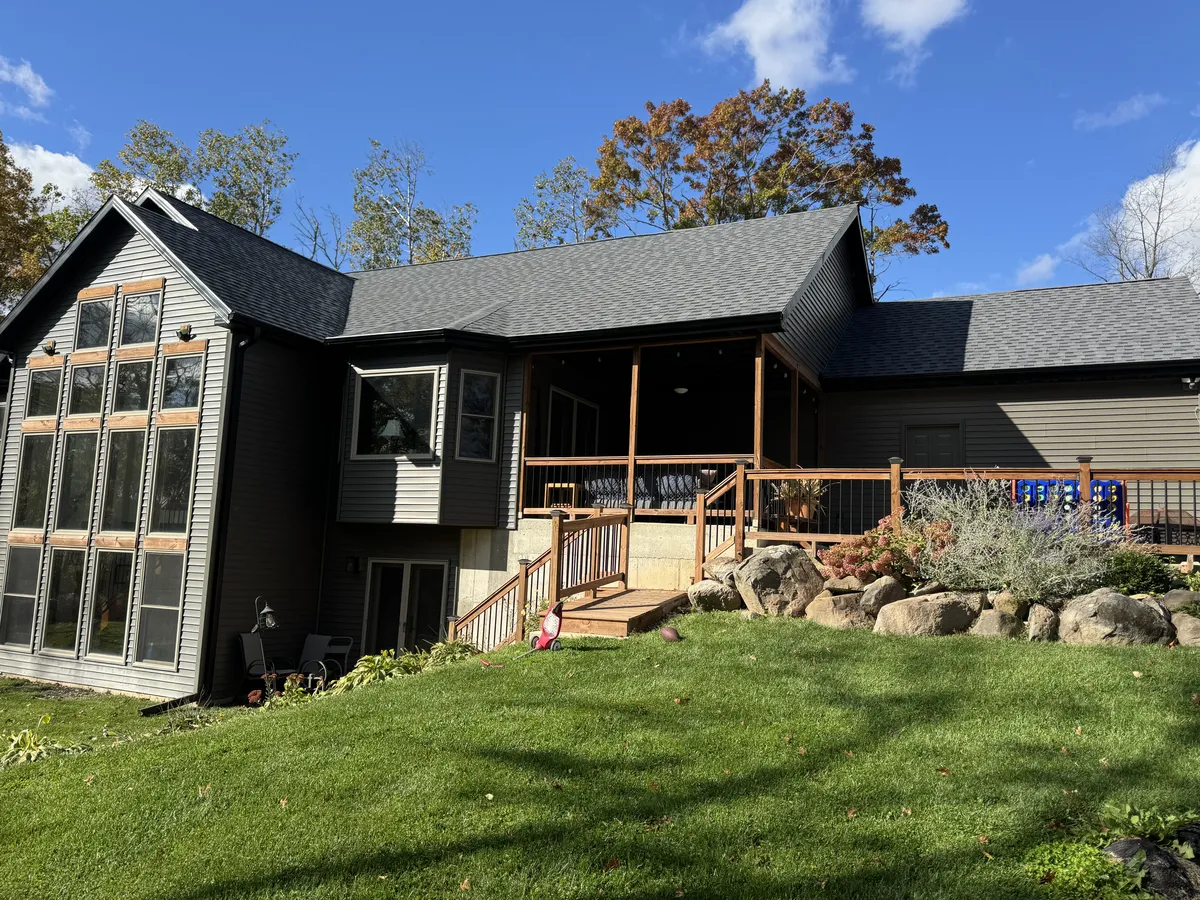 Residential gutter installation viewed from a landscaped backyard porch