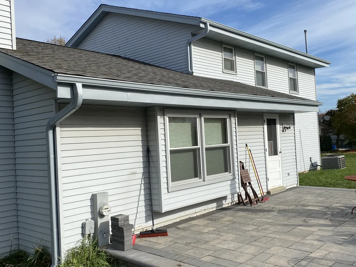 White perforated gutter guard installed along a residential roof edge