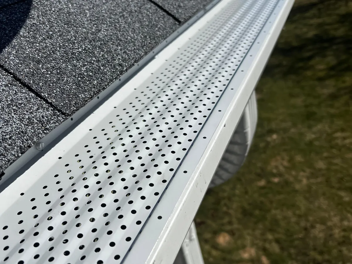 Close-up of a white perforated gutter guard